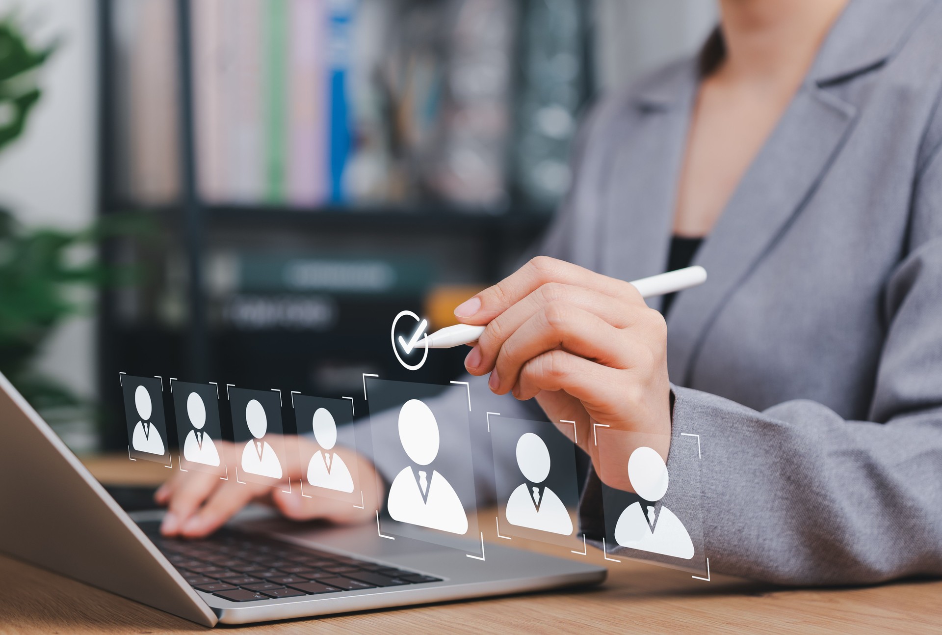 Recruitment and Candidate Selection Process Concept. HR Professional selects candidate from profile icons on laptop screen, symbolizing digital hiring, human resources, and recruitment technology.