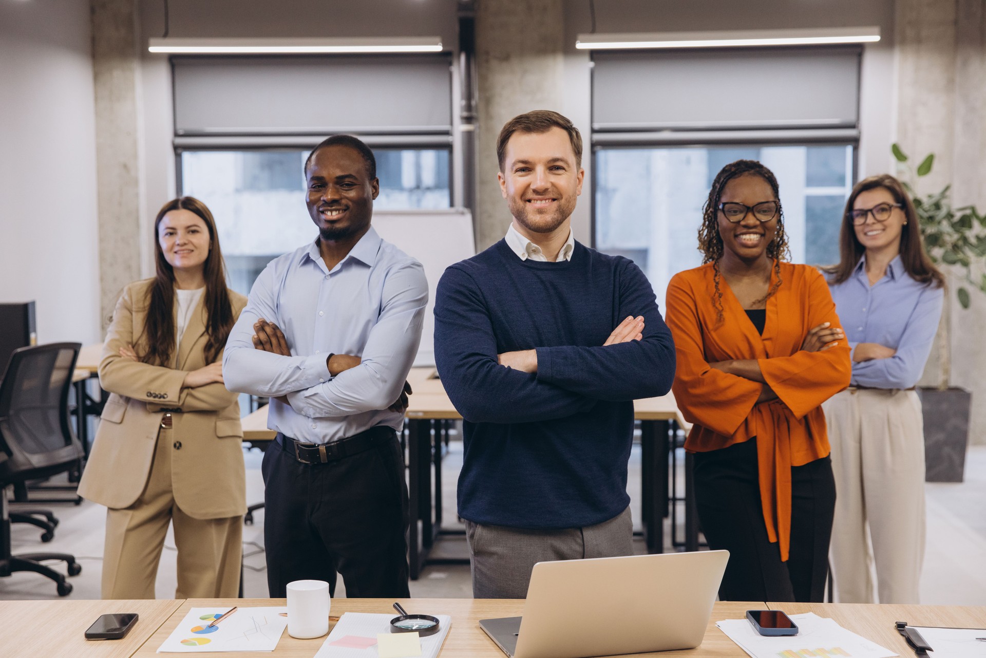 Professional colleagues standing confidently, displaying diverse team unity in modern office environment